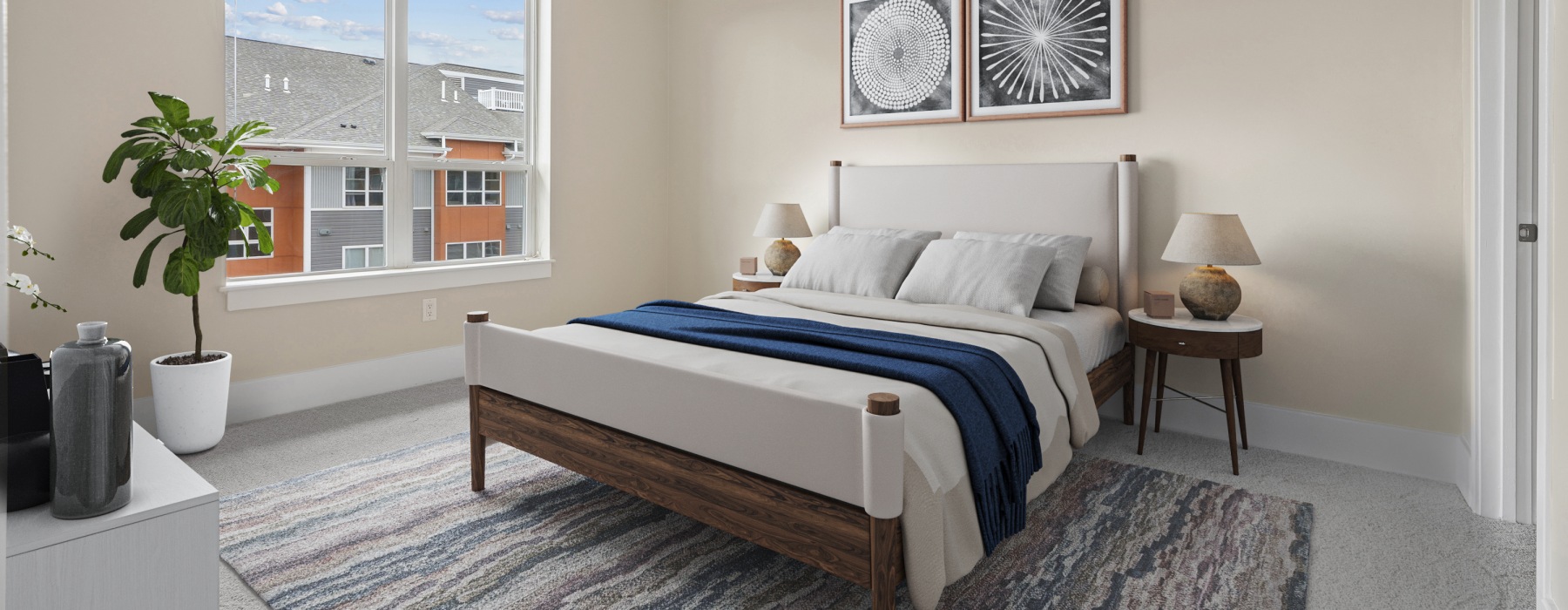 Wide banner view of a modern bedroom layout at Matrix Hudson apartments featuring a large window, contemporary decor, and bright natural light in Hudson, MA.